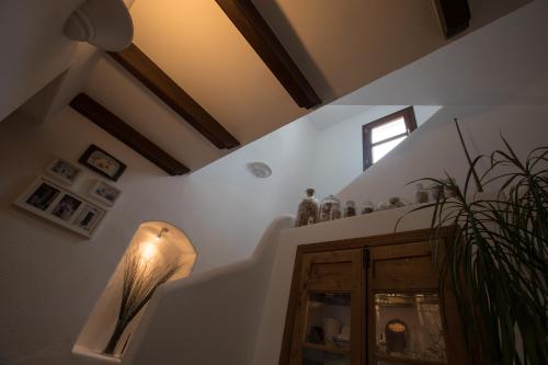ミハスにあるラ カサ デ ラ イグレシアの階段、照明、窓が備わる客室です。
