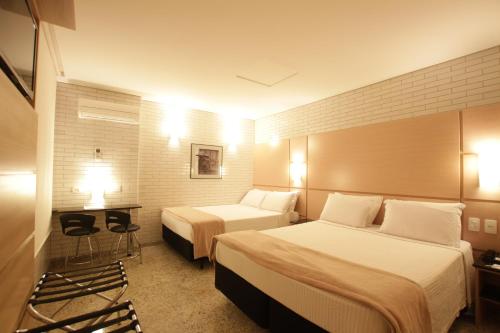 庫里奇巴的住宿－Hotel Confiance Centro Cívico，酒店客房,设有两张床和两张桌子