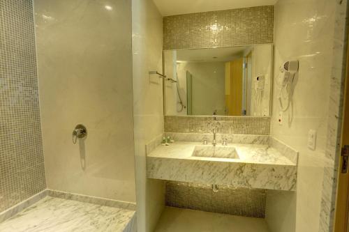 a bathroom with a sink and a mirror at Atlantico Sul Hotel in Rio de Janeiro