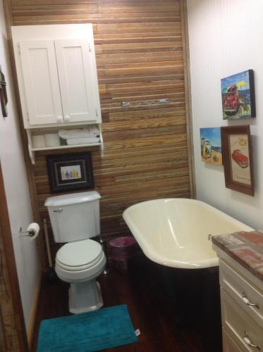 a bathroom with a toilet and a sink and a tub at The Main Street Hotel in Yazoo City