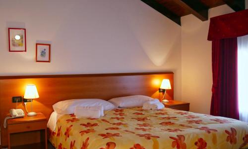 a bedroom with a bed with two towels on it at hotel Vajont in Vaiont