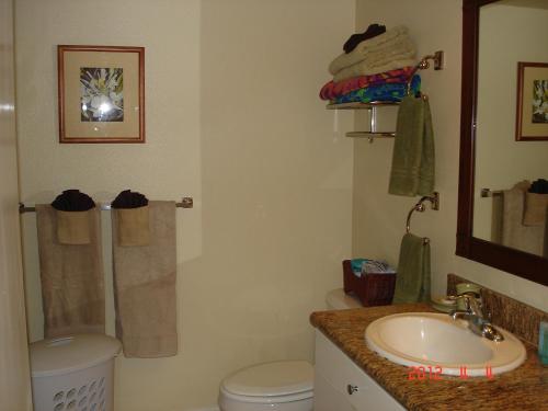 ein Badezimmer mit einem Waschbecken, einem WC und einem Spiegel in der Unterkunft Islander on the Beach Unit 244 in Kapaa