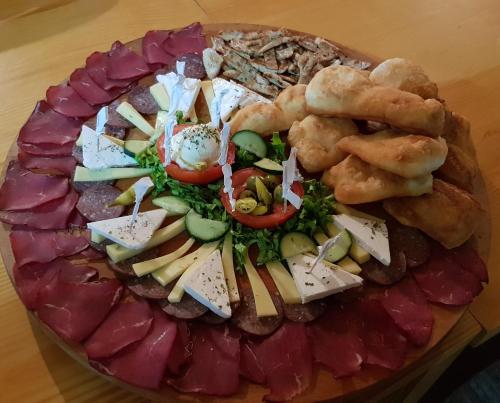 a plate of food with different types of meats and cheese at Pansion Oscar Summer Garden in Mostar