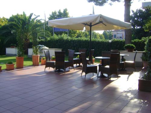 a patio with a table and chairs and an umbrella at Residence Aurora in Albenga