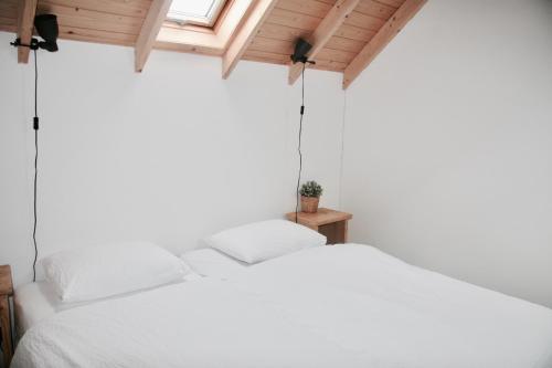 a white bed in a room with a window at Bed & Breakfast Zeeland in Renesse