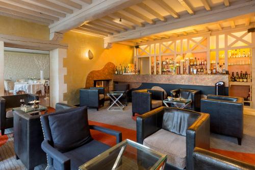 a restaurant with tables and chairs and a bar at Hotel Restaurant Le Dauphin et Le Spa du Prieuré in Caen