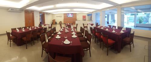a conference room with tables and chairs with plates on them at Olimpo Hotel & Suites in Itauguá