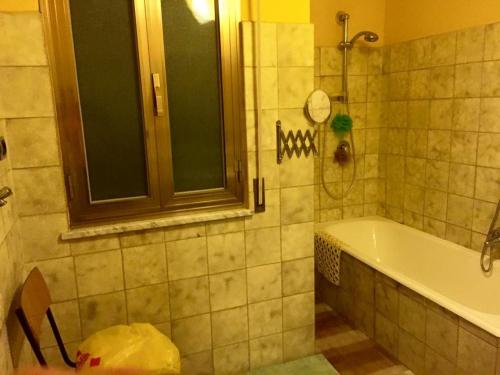 a bathroom with a tub and a window and a sink at Appartamento verde in Marina di Gioiosa Ionica