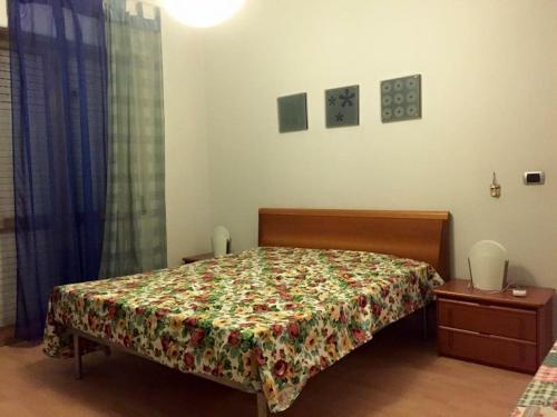 a bedroom with a bed with a floral bedspread at Appartamento verde in Marina di Gioiosa Ionica