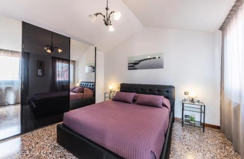 1 dormitorio con cama morada y espejo en Ca' Delfina Holiday Home, en Venecia