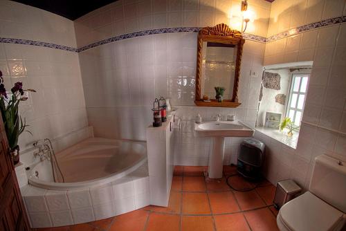 uma casa de banho branca com uma banheira e um lavatório em Geranios Rojos em Las Rosas