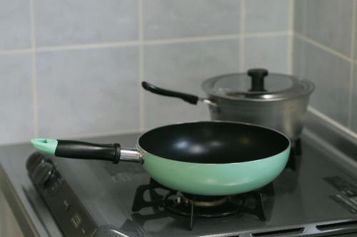 a pan on top of a stove with a pot at A&B Omoromachi Station in Naha