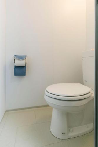 a bathroom with a white toilet and a roll of toilet paper at A&B Omoromachi Station in Naha