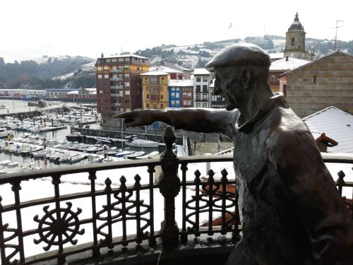 a statue of a man looking out over a harbor at Aldatzeta Ostatua in Bermeo