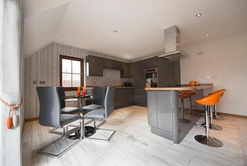 a kitchen with a table and some chairs in it at Tower Ridge Courtyard in Fort William