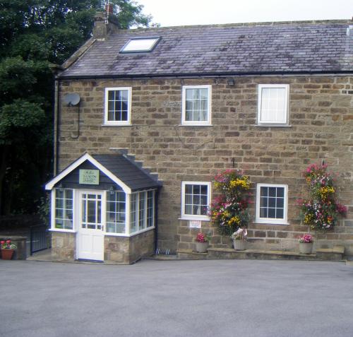 a brick building with a white door and windows at THE FIRS B&B &TEA ROOM in Summer Bridge