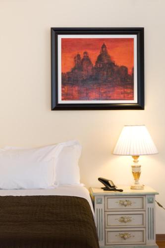 a bedroom with a bed and a picture on the wall at Hotel Antica Fenice in Campalto