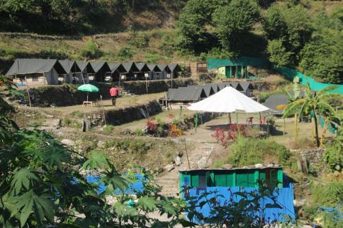 a group of tents and umbrellas on a hill at Natural Camps with InHouse Swimming Pool in Rishīkesh