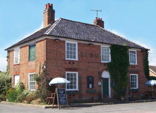 a brick building with an umbrella in front of it at The Theberton Lion in Theberton