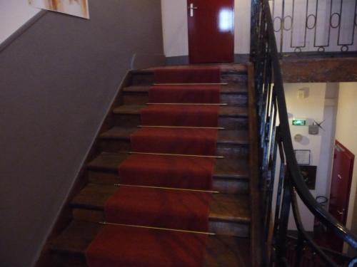 a set of stairs with red carpet at Hôtel du Commerce in Semur-en-Auxois