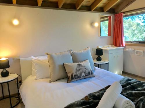 1 dormitorio con 1 cama con un gato sobre una almohada en Bindi - Alpine Getaways's Chalet at Tower Rd en Dinner Plain