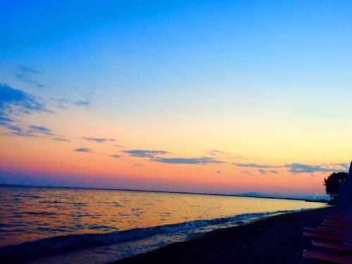a sunset on the beach with the ocean at Corali in Menídion