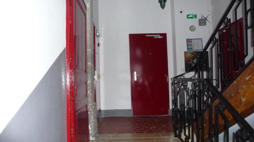 a hallway with a red door in a building at Hôtel du Commerce in Semur-en-Auxois