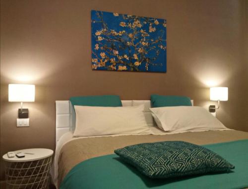 a bedroom with a bed with a painting on the wall at Le Suite dei Due Mari cucinino privato in Taranto