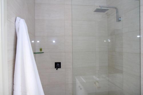 a bathroom with a shower with a white towel at Westering Cottage in Wandin North