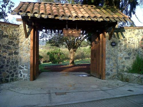 an entrance to a stone building with a wooden door at La Tierra Grande in Zacatlán