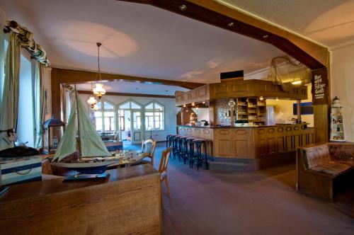 a kitchen and dining room with a table and chairs at Strand-Hotel Lobbe in Lobbe