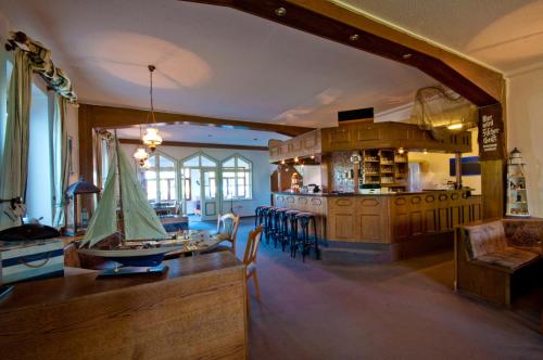 eine Küche und ein Esszimmer mit einem Tisch und Stühlen in der Unterkunft Strand-Hotel Lobbe in Lobbe