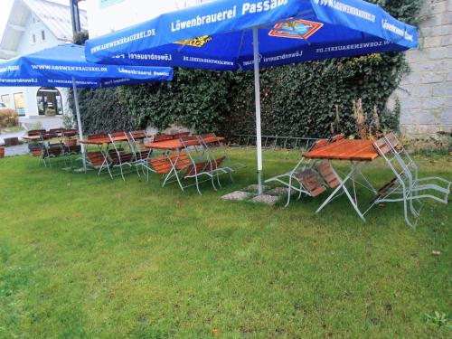 a group of tables and chairs under an umbrella at Pension Waldblick in Spiegelau