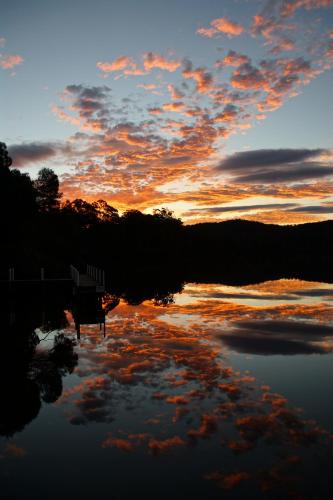 a sunset over a body of water with clouds in the sky at Gipsy Point Lakeside in Gipsy Point