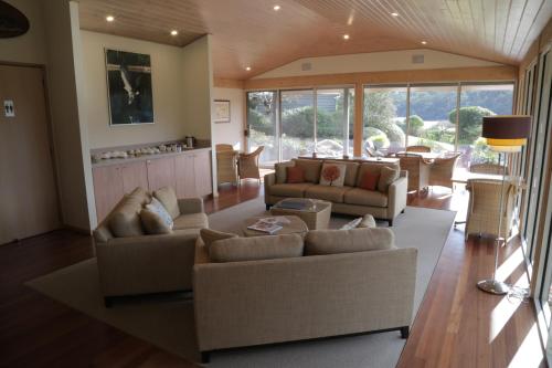 a living room with two couches and a table at Gipsy Point Lakeside in Gipsy Point