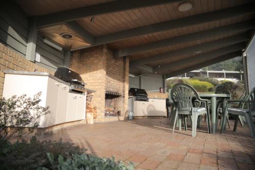 a patio with a table and chairs and a grill at Gipsy Point Lakeside in Gipsy Point