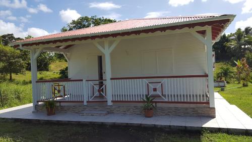 a small white house with a red roof at Cocon des Alizés in Le Moule