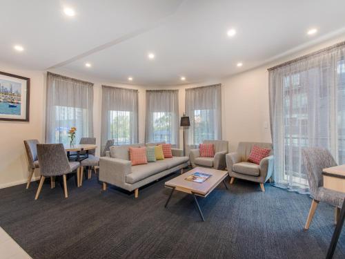 salon z kanapami, krzesłami i stołem w obiekcie Melbourne South Yarra Central Apartment Hotel Official w Melbourne