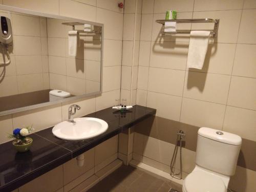 a bathroom with a sink and a toilet and a mirror at Salsa Resort Langkawi By Casa Loma in Pantai Cenang