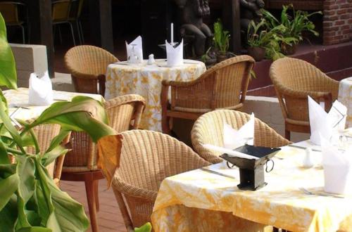 a group of tables and chairs with white napkins at Bakotu Hotel in Kotu