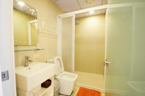 a bathroom with a sink and a toilet and a shower at 綠島 綠堤濱海旅店 in Green Island