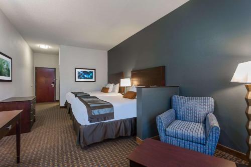 a hotel room with a bed and a chair at Wingate by Wyndham High Point Greensboro in High Point