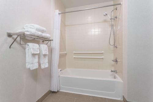 uma casa de banho com uma banheira e um chuveiro com toalhas em Wingate by Wyndham High Point em High Point