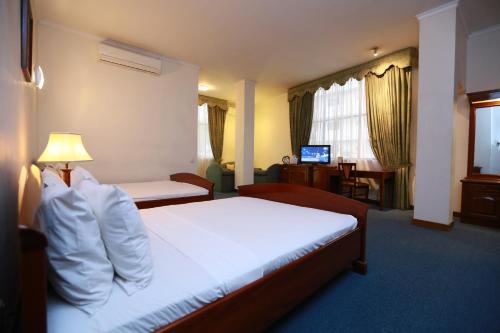 a hotel room with a bed and a desk at Hotel Sapphire in Colombo