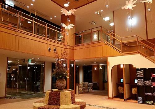 a lobby with a vase in the middle of a building at Hotel New Momiji in Nasushiobara