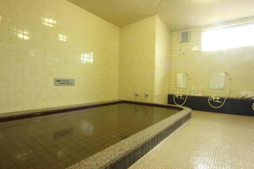 a swimming pool in a bathroom with a shower at Daisen View Heights in Daisen