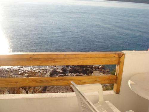 a balcony with a table and chairs and the ocean at House Zaca in Zavala