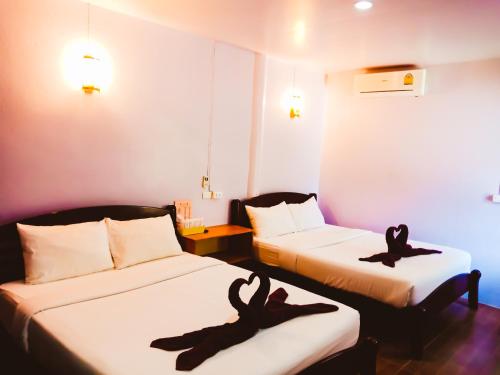 2 posti letto in una stanza con asciugamani neri di Ban Tai Resort a Baan Tai