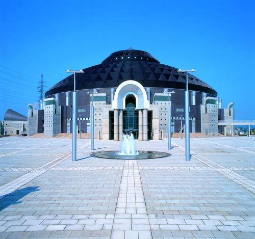 a large building with a fountain in front of it at Sabae City Hotel in Sabae