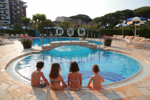 a group of people sitting around a swimming pool at Grand Hotel Gallia in Milano Marittima